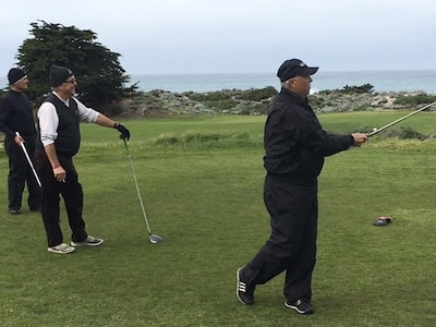 Charles Richesin tees off, with George Kelley (foreground) and<br>his partner Mitch Harrison looking on