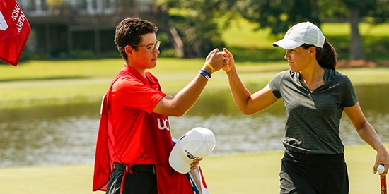 Albane Valenzuela fist bumps her caddie/brother in celebration (USGA/Steve Gibbons)