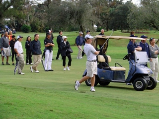 Watches his shot with the gallery