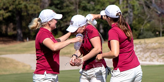 Frida Kinhult (center) gets a bath after her individual victory (SC Athletics photo)
