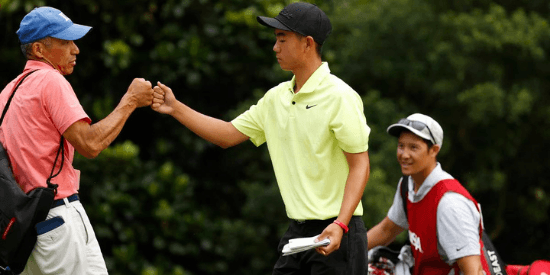 Kelly Chinn celebrates with his father, Colin, after backing up his first-round 64 with a 68 on Tuesday at CCNC. (Chris Keane/USGA)