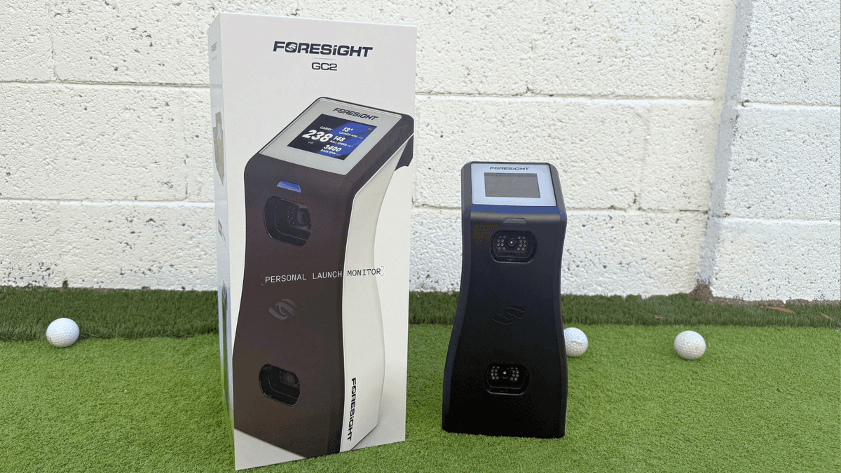 Foresight GC2 launch monitor next to its retail box on turf with golf balls