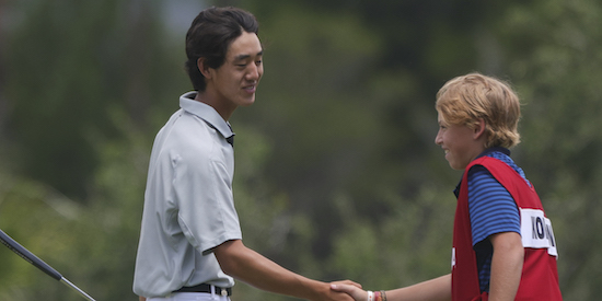 Carson Kim shakes hands with a caddie after shooting 5-under 66 (USGA Photo)